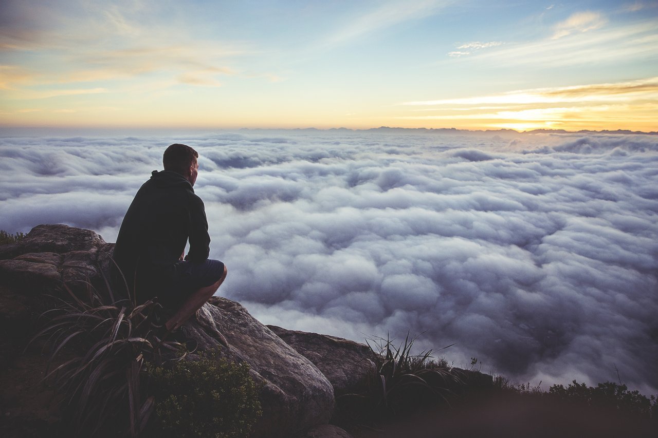 Teen on hill looking out over cloud bank Teen on hill looking out over cloud bank