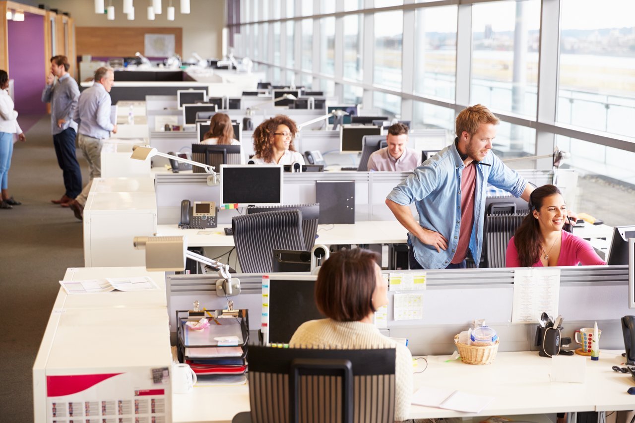 Long rows of desks and people working at them Long rows of desks and people working at them