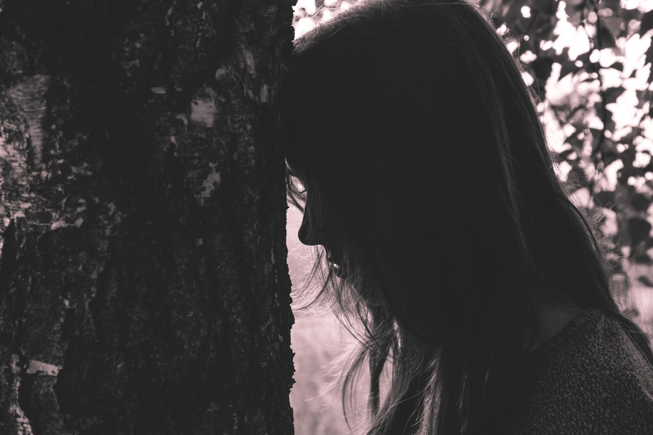 sad teen facing a tree sad teen facing a tree