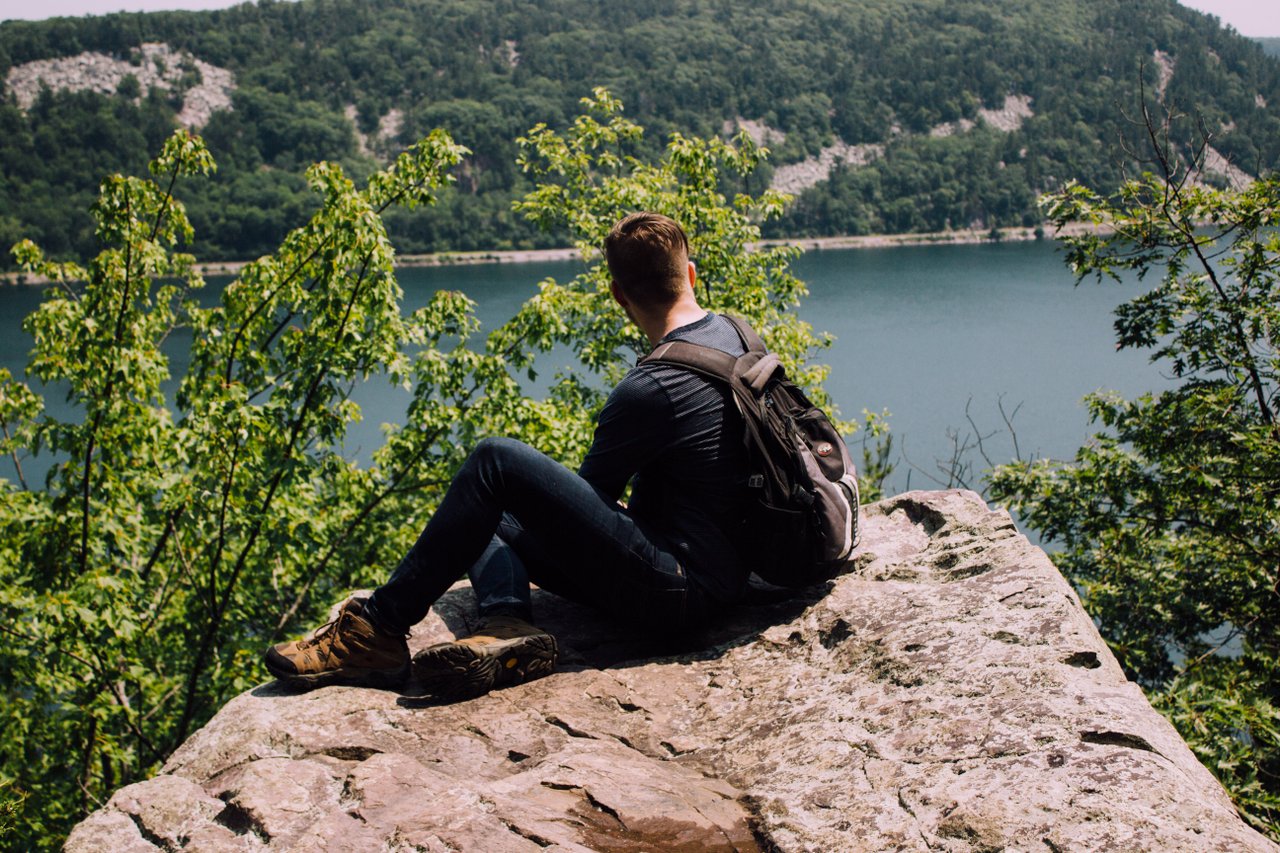 calm teen sitting on rock calm teen sitting on rock