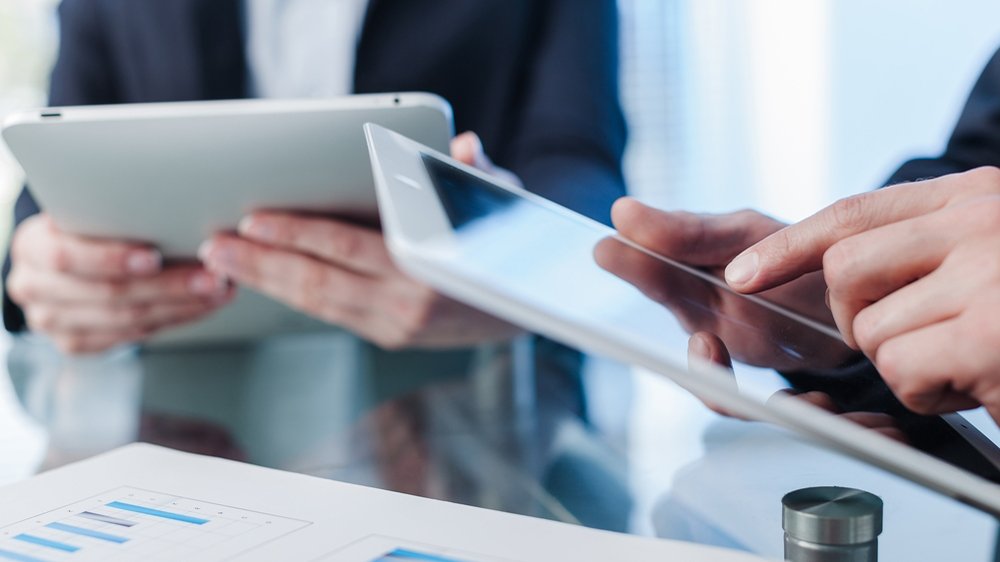 Employees look at tablets Employees look at tablets