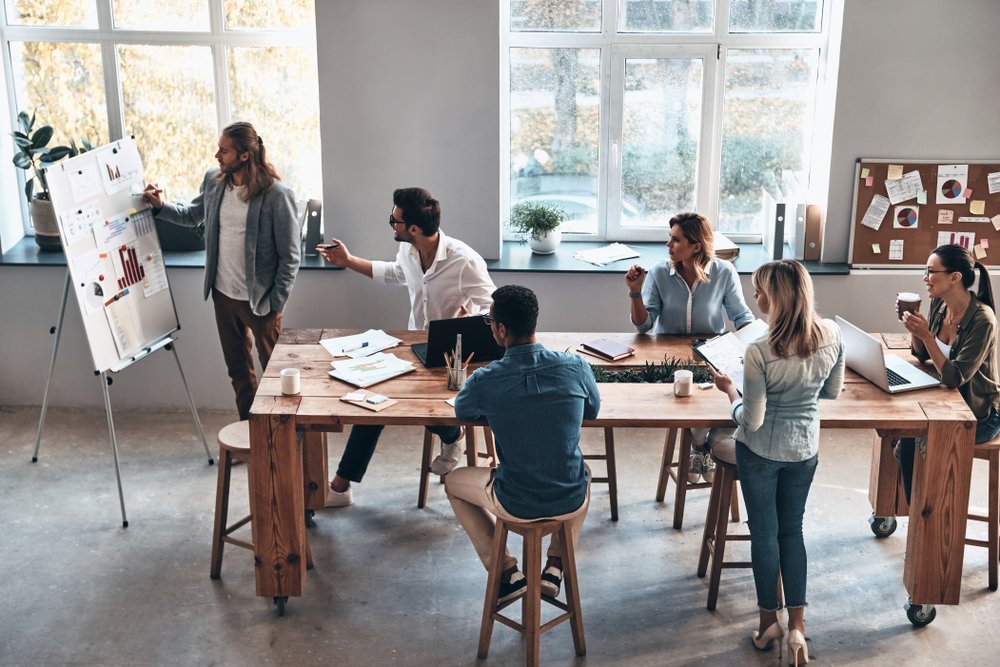 Office team in a meeting going over business details and tasks Office team in a meeting going over business details and tasks