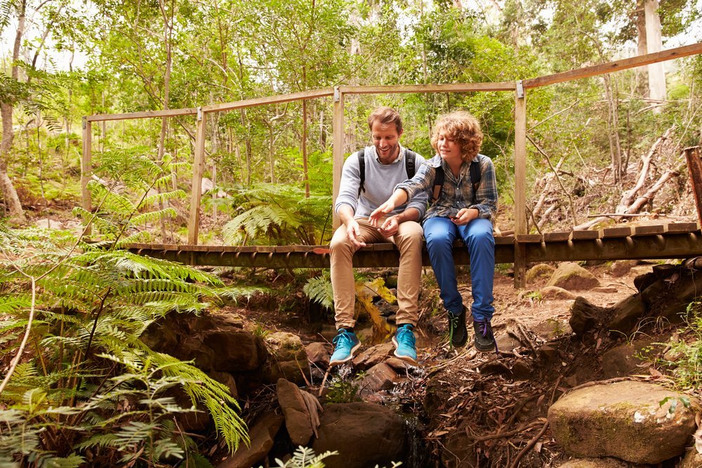 Father and son sitting together in forest Father and son sitting together in forest