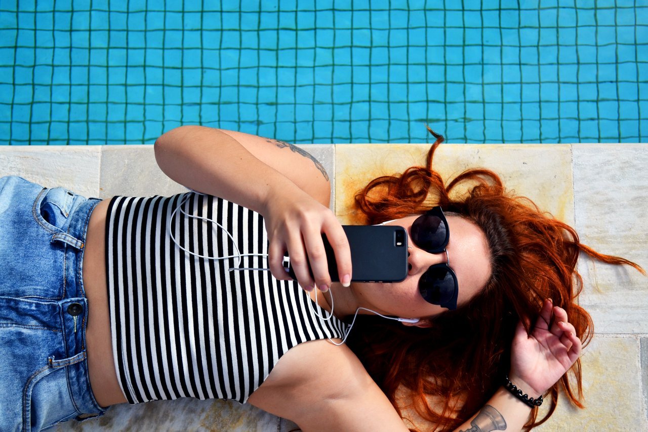 girl-lounging-using-phone-with-headphones girl-lounging-using-phone-with-headphones