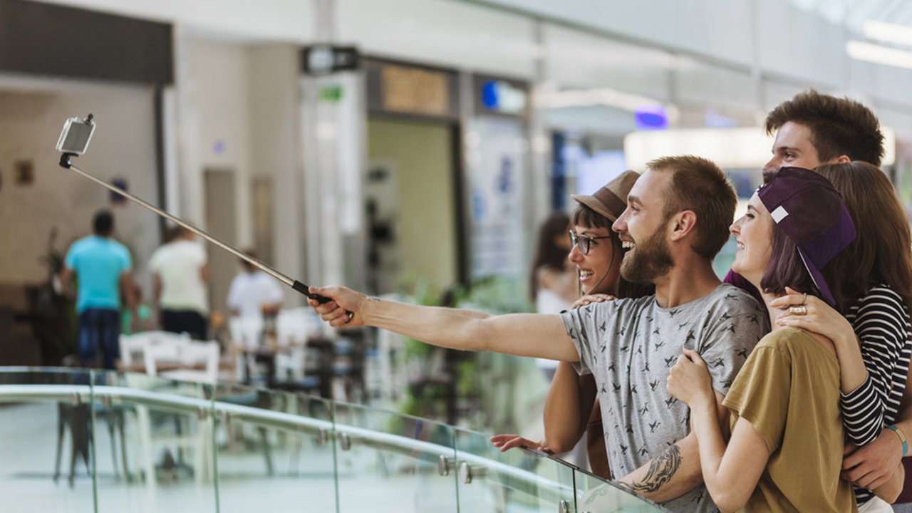 Friends taking selfie with a smartphone inside the mall Friends taking selfie with a smartphone inside the mall