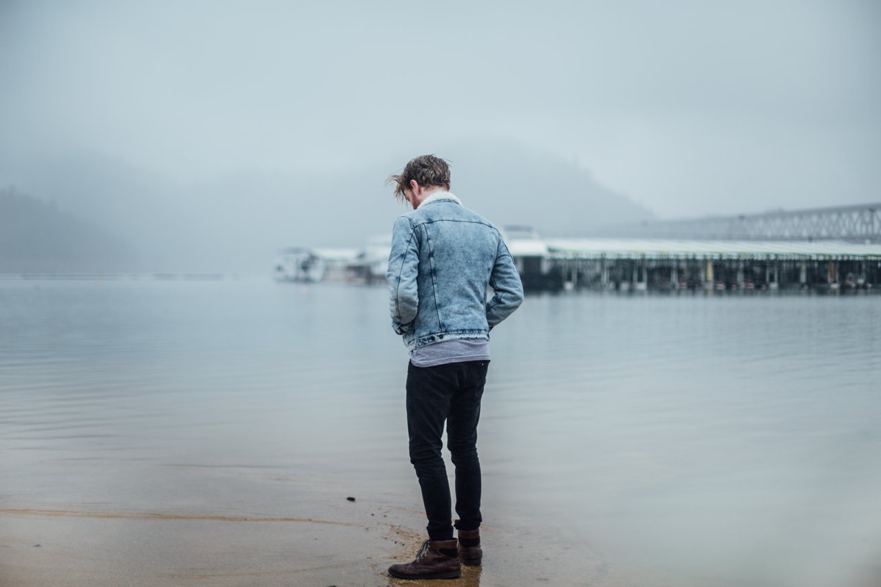 Teen boy standing at water's edge Teen boy standing at water's edge