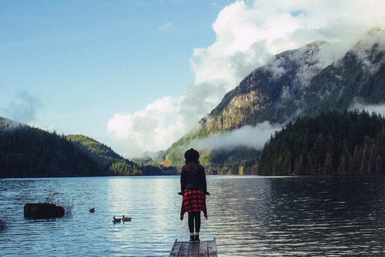 teen standing on a pier outside teen standing on a pier outside