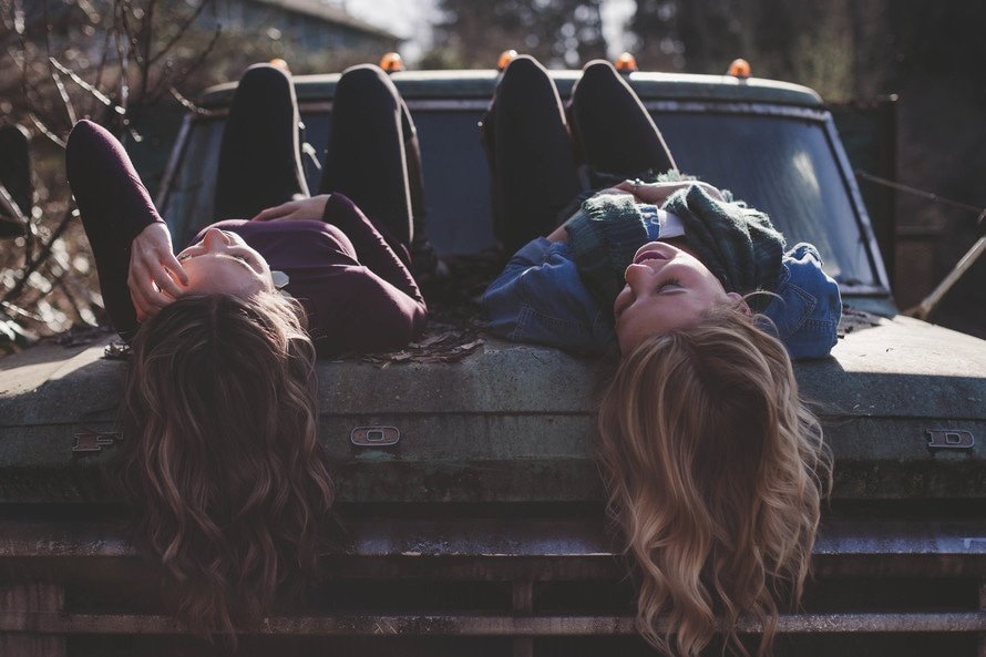 Two friends on the hood of a car Two friends on the hood of a car