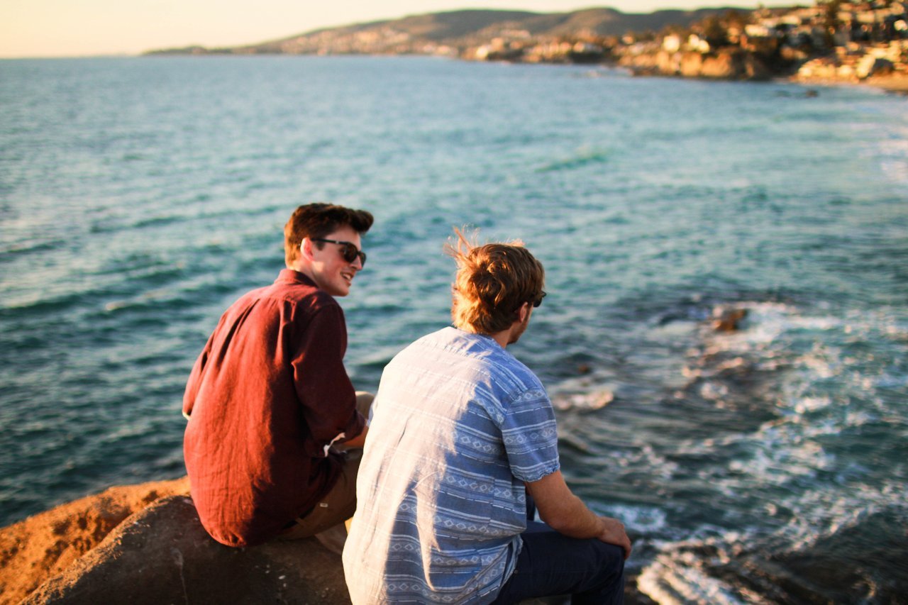 guys-sitting-by-ocean-talking guys-sitting-by-ocean-talking