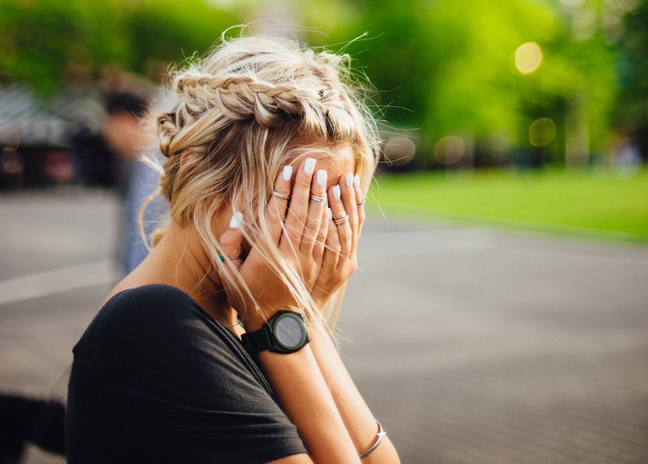 Upset teen girl with hands over her face Upset teen girl with hands over her face