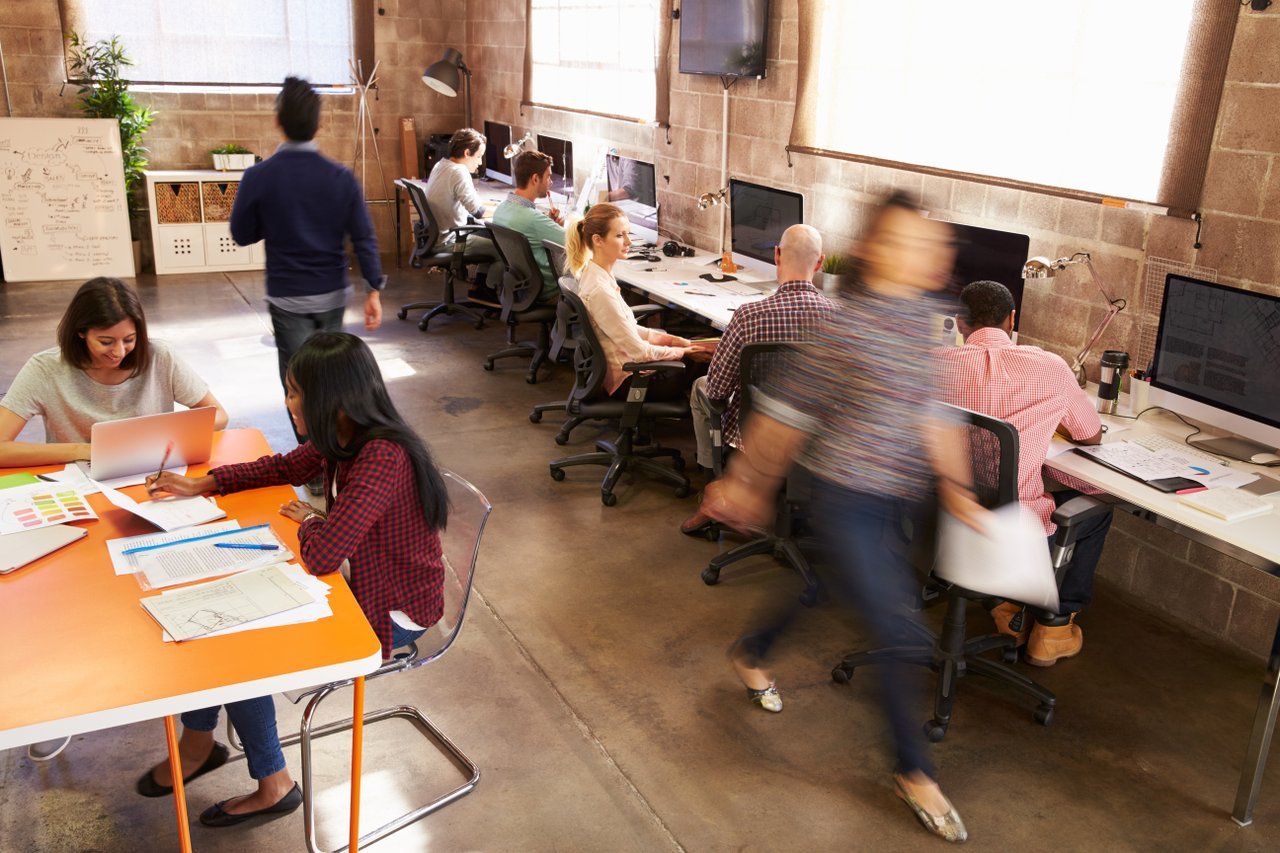 Modern office with people working at laptops and table Modern office with people working at laptops and table